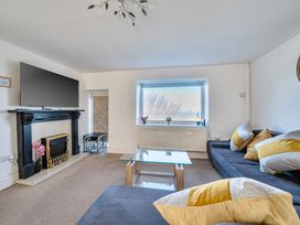 A living room with a sofa and television at Sea view cottage Penmaenmawr