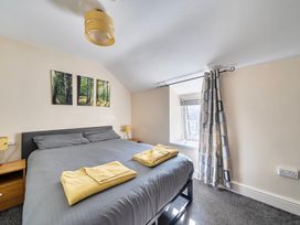 A bedroom with a bed and wall art at Sea view cottage in Penmaenmawr