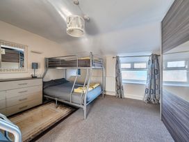A bedroom with a bunk bed and dresser at Sea view cottage Penmaenmawr