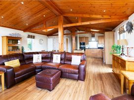 A living room with a sofa and dining area at Hedgehog Lodge in York