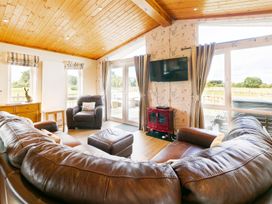 A living room with a sofa and television at Hedgehog Lodge in York