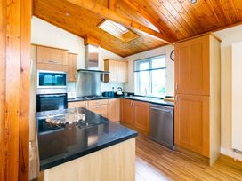 A kitchen with cabinets and appliances at Hedgehog Lodge in York
