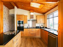 A kitchen with wood cabinets and appliances at Hedgehog Lodge in York