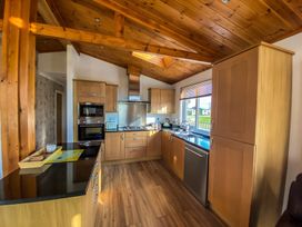 A kitchen with cabinets and appliances at Hedgehog Lodge in York