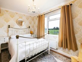 A bedroom with a bed and nightstand at Hedgehog Lodge in York