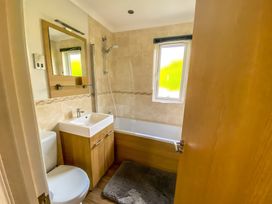 A bathroom with a sink, toilet, and bathtub at Hedgehog Lodge in York