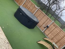An outdoor area with a hot tub and lawn chair at Cotswold Nights Away Evesham