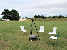 An outdoor area with a campfire ring and chairs at Cotswold Nights Away Evesham