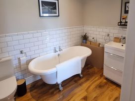 A bathroom with a bathtub, toilet, and sink at Fox Lodge in York