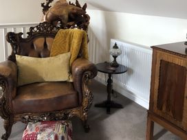 A snug area with an armchair and side table at Country Retreat Sleeps 2 Holyhead