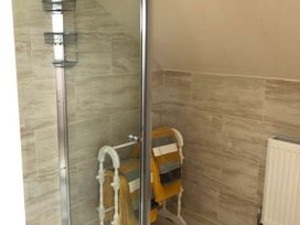 A bathroom with a shower and towels on a rack at Country Retreat Sleeps 2 Holyhead