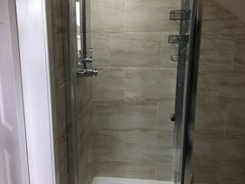 A shower stall with glass door and tile walls at Country Retreat Sleeps 2 Holyhead