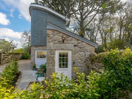 An outdoor view of a stone building with a pathway and plants at The Old Well House in Redruth
