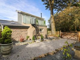 An outdoor area with a spiral staircase and planters at The Old Well House in Redruth