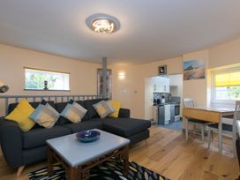 A living room with a sofa and dining table at The Old Well House in Redruth
