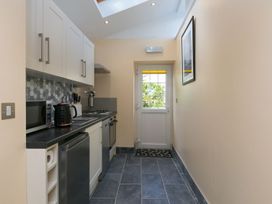 A kitchen with appliances and a door at The Old Well House Redruth