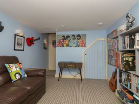 A snug area with a sofa and bookshelf at The Old Well House in Redruth