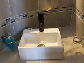 A sink with tap and soap dispenser in a bathroom at The Old Well House Redruth