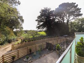 A garden with trees and a fence at The Old Well House in Redruth