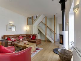 A living room with a sofa and a stove at Poppyfields Stable in Redruth