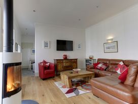 A living room with a fireplace and furniture at Poppyfields Stable in Redruth