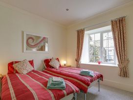 A bedroom with two beds and a window at Poppyfields Stable in Redruth