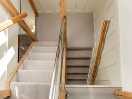 A staircase with carpeted steps and wooden handrails at Poppyfields Stable in Redruth