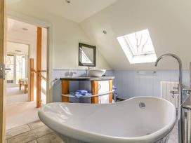 A bathroom with a bathtub and vanity at Poppyfields Stable Redruth