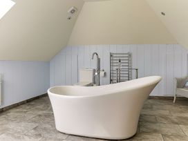 A bathroom featuring a bathtub and a toilet at Poppyfields Stable Redruth