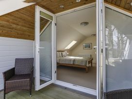 A bedroom with sliding doors and a chair at Poppyfields Stable Redruth