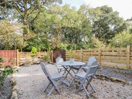 A garden with a table and chairs surrounded by gravel at Poppyfields Stable in Redruth