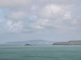 An ocean view with an island and lighthouse at Poppyfields Stable Redruth