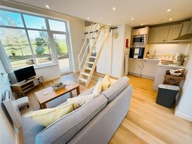 A living room with a sofa and staircase at Honey Bee Cottage Welshpool
