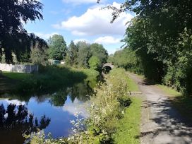 A canal with a bridge and a pathway alongside it at Honey Bee Cottage in Welshpool