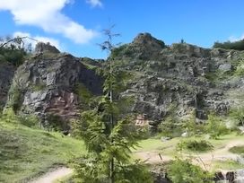 A natural landscape with rock formations and trees at Honey Bee Cottage in Welshpool