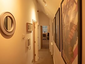 A hallway with framed artwork and a mirror at 2nd Floor Apartment in Llandudno
