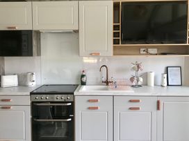 A kitchen with cabinets, sink and cooking stove at Inverness Lodge in Inverness