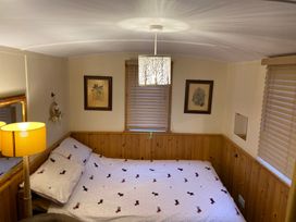 A bedroom with a bed and lamp at Shepherds hut in Dumfries