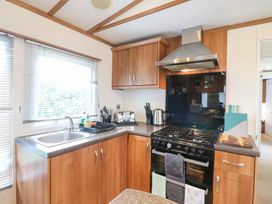 A kitchen with cabinets, stove, and sink at No 35 MP Billing Aquadrome Holiday Park