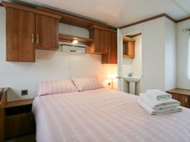 A bedroom with a bed and a bathroom sink at No 35 MP Billing Aquadrome Holiday Park