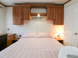 A bedroom with a bed and a bedside lamp at No 35 MP Billing Aquadrome Holiday Park