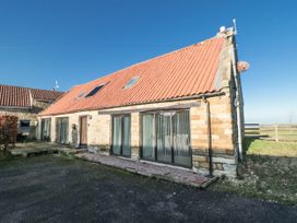 A house with a red roof and large windows at Millstone Cottage Sneaton Thorpe near Whitby