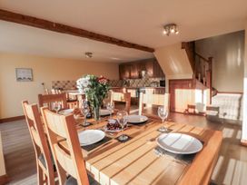 A dining room with a wooden table set for a meal at Millstone Cottage in Sneaton Thorpe near Whitby