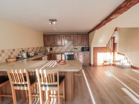 A kitchen with wooden cabinets and countertops at Millstone Cottage Sneaton Thorpe near Whitby