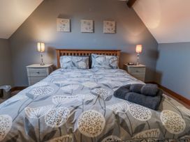 A bedroom with a bed and bedside tables at Millstone Cottage Sneaton Thorpe near Whitby