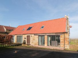 A house with a red roof and windows at Millstone Cottage Sneaton Thorpe near Whitby