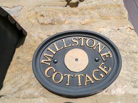A nameplate that reads Millstone Cottage on a stone wall at Millstone Cottage Sneaton Thorpe near Whitby