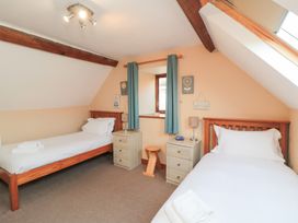 A bedroom with two single beds and a window at Millstone Cottage Sneaton Thorpe near Whitby