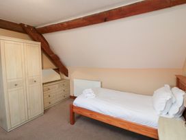 A bedroom with a bed and wardrobe at Millstone Cottage Sneaton Thorpe near Whitby