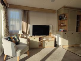 A living room with a television and armchair at Harbour View in Poole